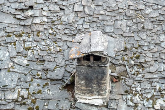 old chimney at a house with old slate roof in Caspoggio in Region Valmalenco, Italy