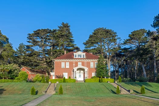 scenic historic houses in battery park near golden gate bridge in green landscape in San Francisco, USA