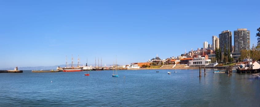panoramic view to pier in San Francisco with modern buildings and old traditional pier and historic ships, USA