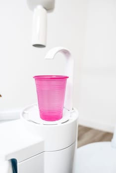 red plastic cup at a dentists chair for cleaning the mouth
