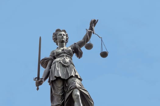 lady justice with sword and balance wage in Frankfurt under blue sky