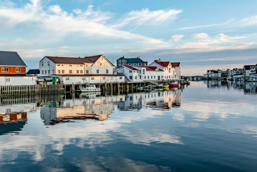 scenic reflection of typical wooden houses in the harbor of Svolvaer,Norway in late afternoon