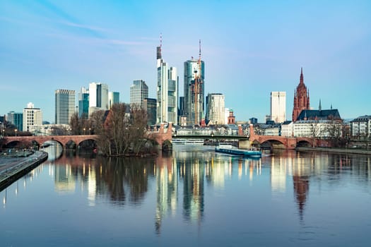 scenic skyline of Frankfurt am Main with reflection in the river in early morning, Hesse, Germany