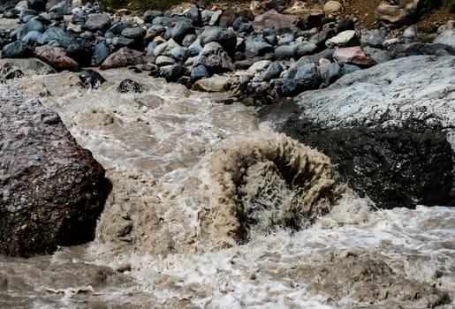 A mountain river, a rushing stream of water in the mountains.