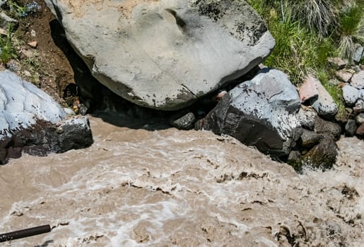 A mountain river, a rushing stream of water in the mountains.