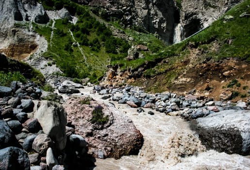 A mountain river, a rushing stream of water in the mountains.