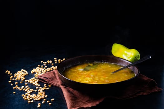 Homemade healthy vegetable soup with some bread and an onion