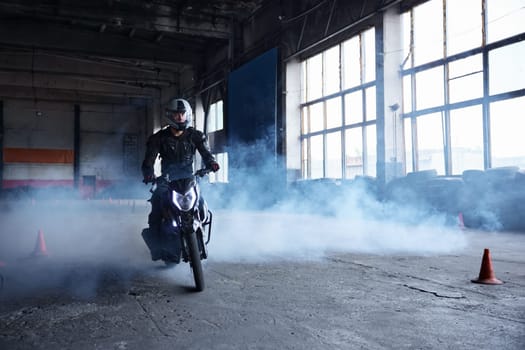 Motor rider making difficult and dangerous stunt on his motorbike riding fast at driving school motordrome