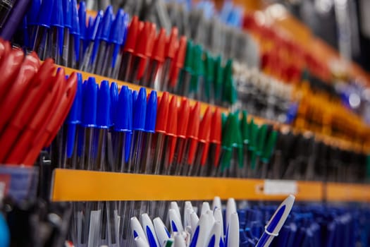 Showcase with different kind of pens office or school writing supplies at stationery store. Various studying and working equipment on rack shelves