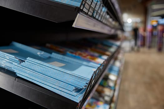 Stationary shop rack with paper copy-books assortment selective focus. Retail place showcase with studying supplies. Best prices for education preparation