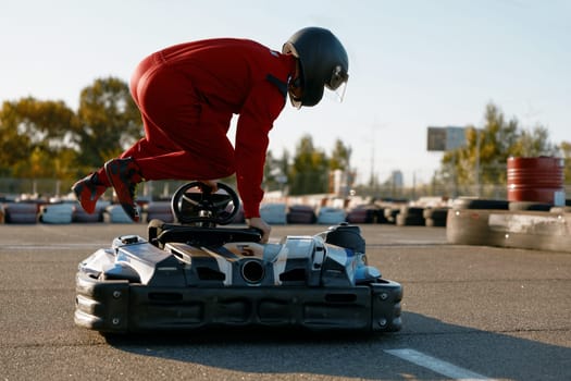 Excited man driver jumping into go-cart getting ready for speed race entertainment. Masculine hobby concept