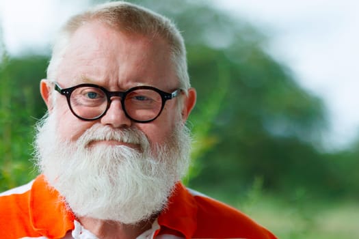 Sad and frustrated senior man with eye glasses and full beard looking at camera.