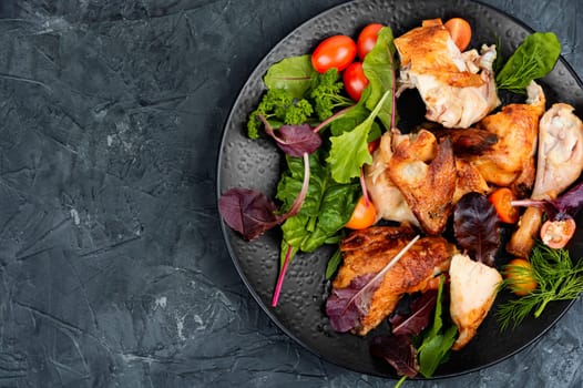 Roasted chicken pieces and salad. Flat lay with copy space.