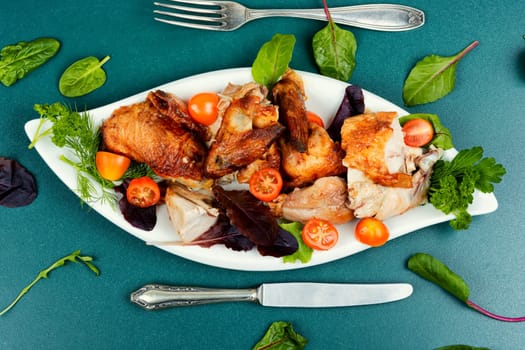 Roasted chicken pieces and salad. Flat lay with copy space.
