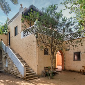 A tranquil courtyard showcasing traditional building style and flora, inviting a sense of serenity and historical charm