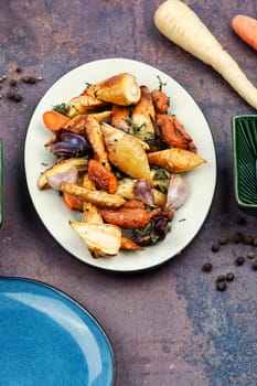 Winter garnish of baked parsnip root, carrots and garlic. Copy space.