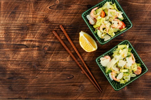 Asian salad with shrimp,prawns and avocado slices on a vintage wooden background. Healthy eating. Space for text.
