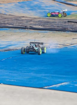 Merida, Spain - Jan 28th, 2024: Extremadura 1/8tt gas Championship RC Car. Cars making a curve over blue turf