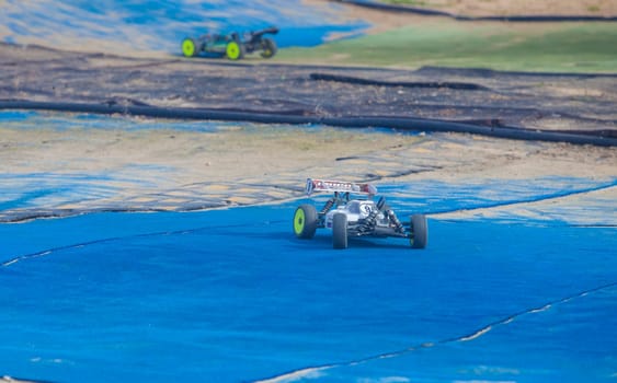 Merida, Spain - Jan 28th, 2024: Extremadura 1/8tt gas Championship RC Car. Cars making a curve over blue turf