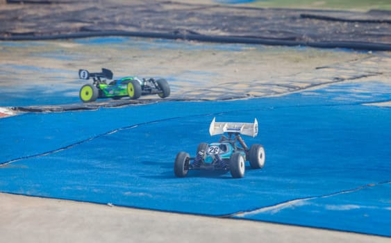 Merida, Spain - Jan 28th, 2024: Extremadura 1/8tt gas Championship RC Car. Cars making a curve over blue turf