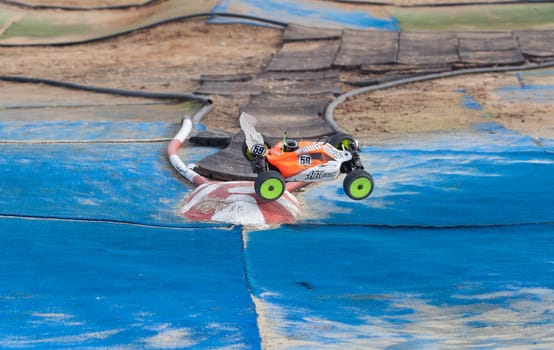 Merida, Spain - Jan 28th, 2024: Extremadura 1/8tt gas Championship RC Car. Cars making a curve over blue turf