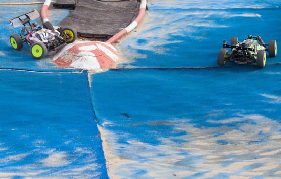 Merida, Spain - Jan 28th, 2024: Extremadura 1/8tt gas Championship RC Car. Cars making a curve over blue turf