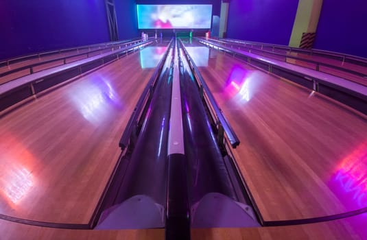 Four lane bowling alley with bumpers on for kids and beginners. These barriers stick out of the gutter the balls