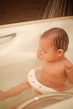A small child takes a shower in the bathroom close-up