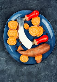 Raw sweet potatoes or batatas. Yam on concrete kitchen table. Dietary food. Space for text.