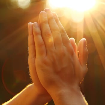 Two hands come together in a prayer pose, backlit by a radiant sunrise, creating an aura of hope and spirituality. The image symbolizes faith and the seeking of divine guidance