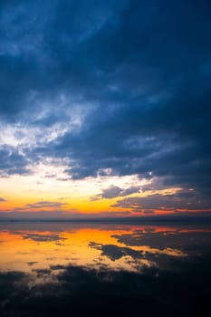 Dramatic sunset at the Lake Neusiedlersee in Austria with colorful orange and red illuminated cloudy sky