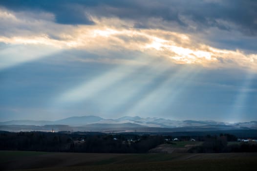 Sun breaking through large whole in clouds