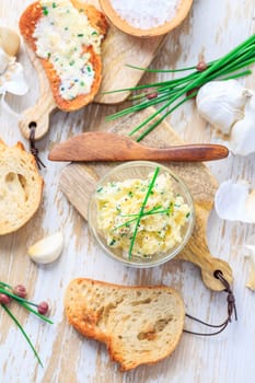 Homemade garlic butter with chives and fresh roasted baguette with salt