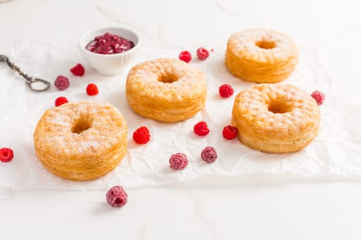 Cronuts - delicious fusion of croissant and donut with raspberry jam. Half-donut and half-croissant pastry