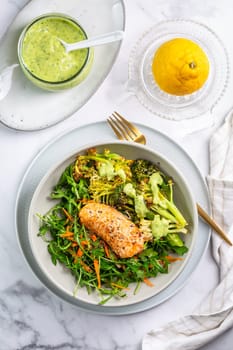 Grilled salmon fillet with parmesan broccoli and fresh vegetable salad, avocado dressing. Mediterranean diet.