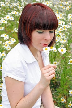A young woman in the middle of chamomile blossoms