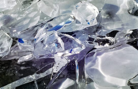 Frozen icicles of fresh water of lake Baikal. Winter on the Baikal, ice and snow on the lake. The beauty of the nature of Baikal in winter.