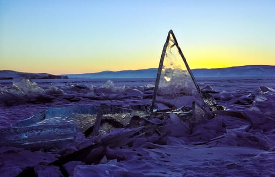 Frozen icicles of fresh water of lake Baikal. Winter on the Baikal, ice and snow on the lake. The beauty of the nature of Baikal in winter.