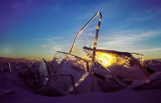 Frozen icicles of fresh water of lake Baikal. Winter on the Baikal, ice and snow on the lake. The beauty of the nature of Baikal in winter.
