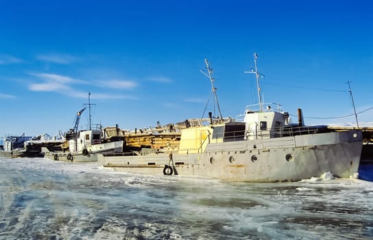Pier ships and boats on the Baikal. Frozen port on baikal.