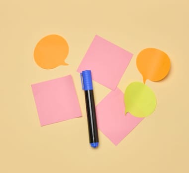 Various paper stickers and felt-tip pens on a yellow background, top view