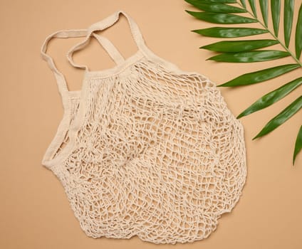 Textile grocery bag on brown background, top view
