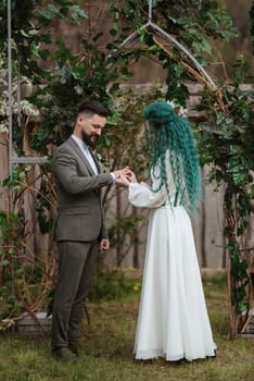 wedding ceremony of the newlyweds in a country cottage on a green hill