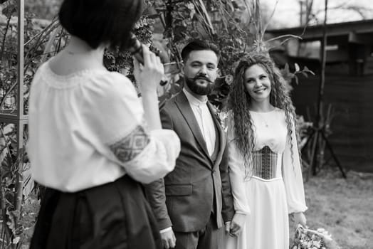 wedding ceremony of the newlyweds in a country cottage on a green hill