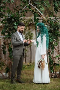 wedding ceremony of the newlyweds in a country cottage on a green hill