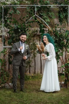 wedding ceremony of the newlyweds in a country cottage on a green hill