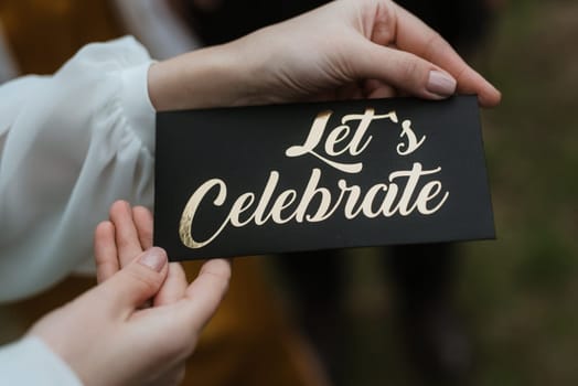 let's celebrate sign in the hands of the bride girl