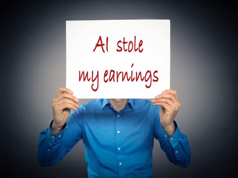 Business man holding a white sign with the text AI stole my earnings in front of his face
