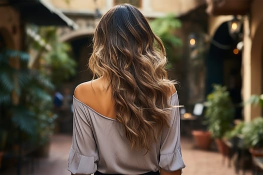An elegant woman in the courtyard shows off her long wavy hair.