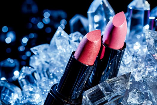 Two lipsticks on glistening ice.